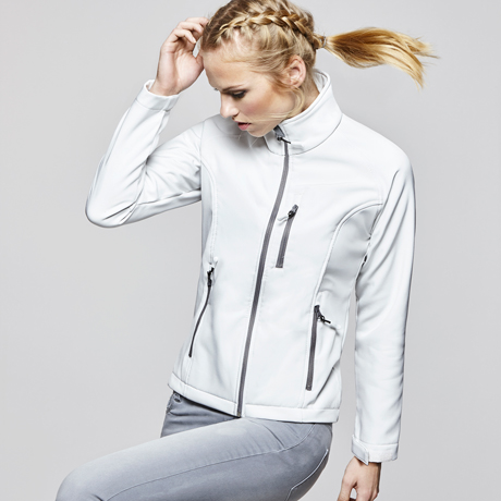 Mujer con chaqueta softshell blanca con cremallera y bolsillos sobre fondo neutro