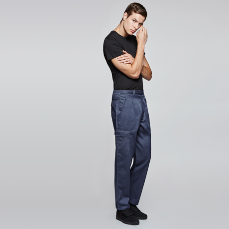 Hombre con camiseta negra y pantalones de trabajo azul marino sobre fondo gris